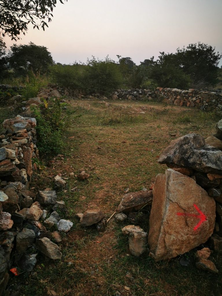 Le muret derrière lequel nous nous sommes cachées. La flèche rose sur le rocher est le balisage sommaire.