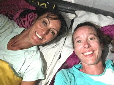 Christelle et EMilie sont couchées sous la tente, elles ont le sourire